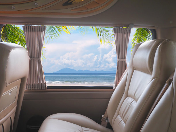 在夏天的沙滩背景下，货车里空荡荡的棕色真皮座椅。图片下载