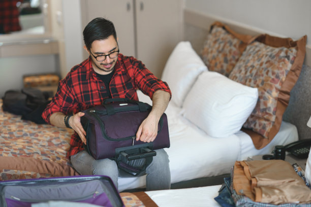 一个年轻人正在为旅行打包行李图片下载