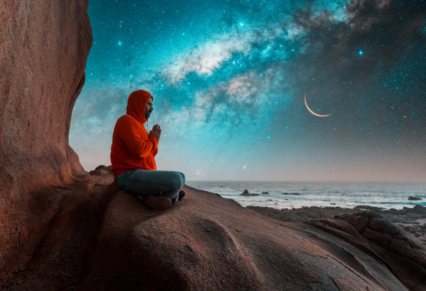 人们坐在山顶上，以银河为背景，冥想或思考星空图片下载
