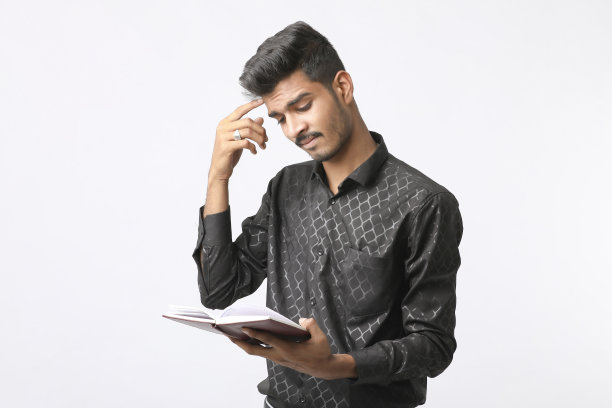 年轻的印度大学生手里拿着日记，背景是白色的。图片下载