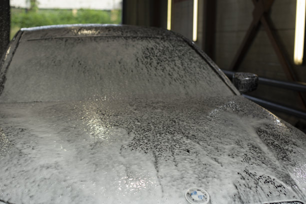 洗车房的车。泡沫车。白色的肥皂溶液。清洁的交通工具。图片下载