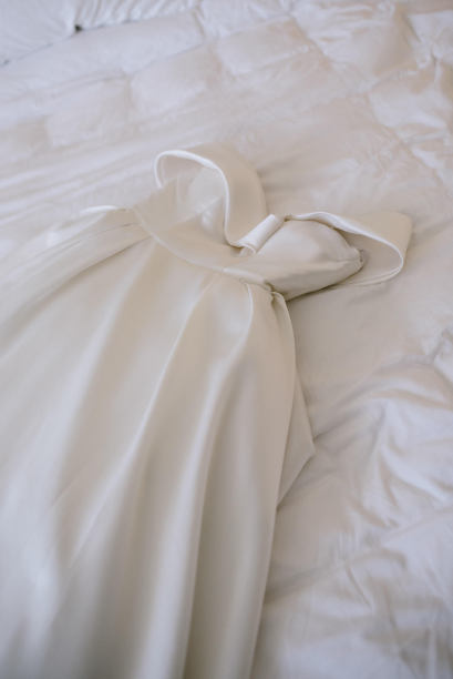 婚纱挂在房间里。清晨的风景为身穿白色婚纱、捧着花束的新娘。图片下载