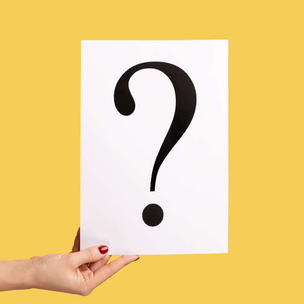 特写侧视图肖像的女人手握白色广告牌上的问号。图片下载