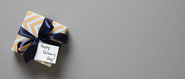 父亲节快乐横幅设计。灰色背景上印有“父亲节快乐”标签的复古礼盒。顶部视图与复制空间图片下载