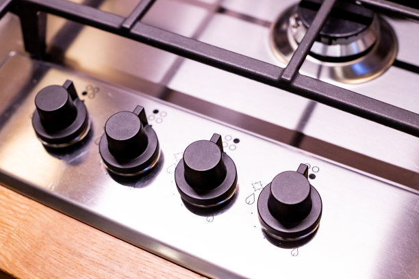 厨灶。有燃烧丙烷气体火焰的煤气灶。现代滚刀煤气炉由钢化的白色玻璃制成，使用天然气或丙烷做饭。产业资源与经济观念。图片下载