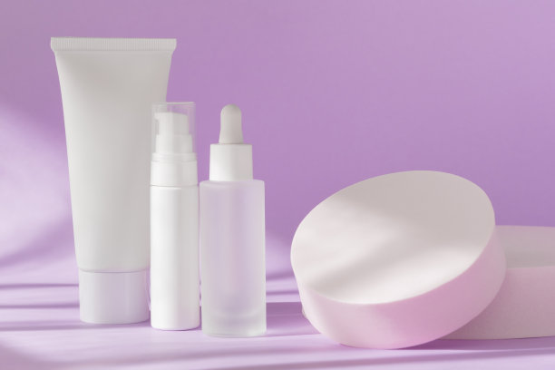 丁香上的皮肤护理化妆品瓶模型。乳膏罐管，血清玻璃瓶模板，乳液分配器在自然背景与阴影，正面视图。品牌温泉包装模拟。图片下载