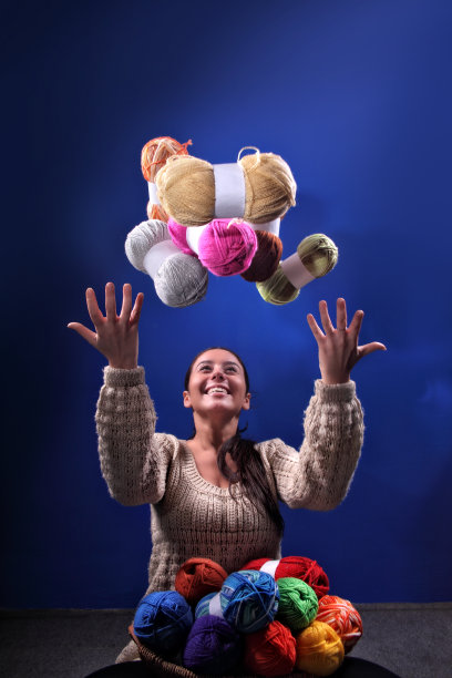 美丽的深色头发的女人的肖像与一束彩色的羊毛球图片下载