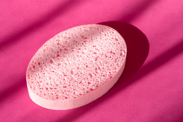 紫色表面的浴海绵。椭圆形温泉淋浴磨砂配件。皮肤护理的概念图片下载