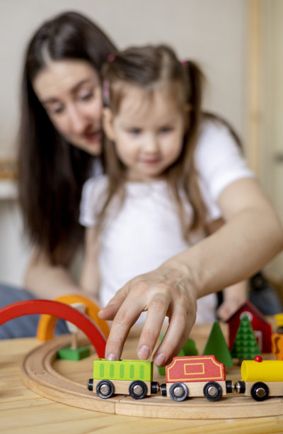 蒙特梭利的材料。妈妈和女儿通过游戏学习交通。木制的铁路。图片下载