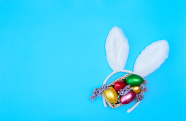 白色复活节兔子耳朵与短语快乐复活节在黄色的背景上明亮的字母。复活节快乐的概念。平面布局风格与复制空间图片下载