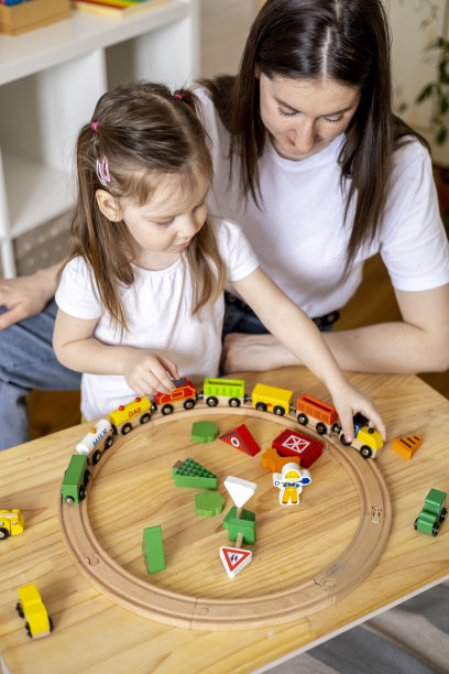 蒙特梭利的材料。妈妈和女儿通过游戏学习交通。木制的铁路。图片下载