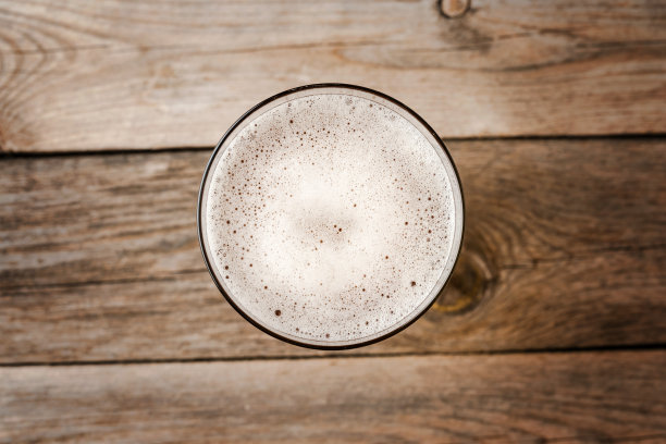 啤酒杯放在木桌上。近距离图片下载