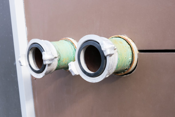 建筑物墙上的消防栓连接到消防车的特写图片下载