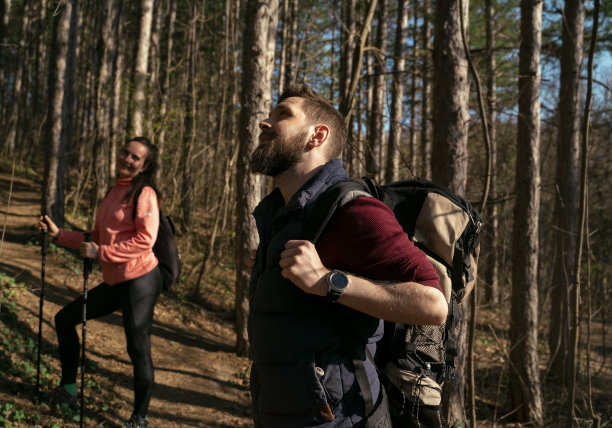 年轻夫妇徒步穿过森林，享受新鲜空气图片下载