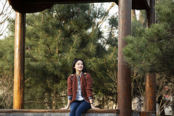 年轻的中国大学生在公园里休息图片下载