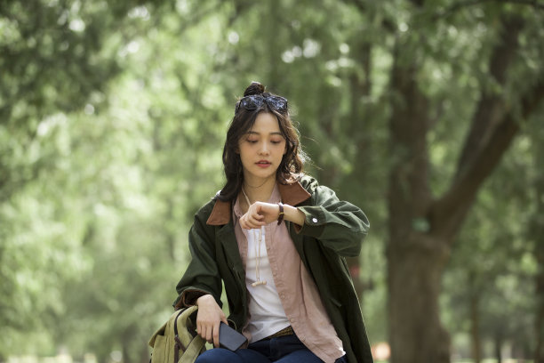 女游客在森林公园里看时间-存量照片图片下载