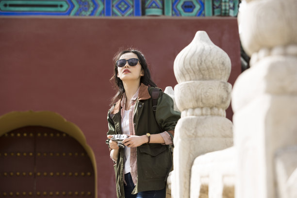 年轻的女游客在古拱桥上拍照图片下载