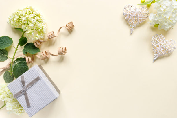 米色背景上带礼品盒的绣球花精美花束图片下载