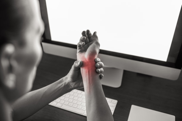 一个在家工作，手腕疼痛的女人。图片下载