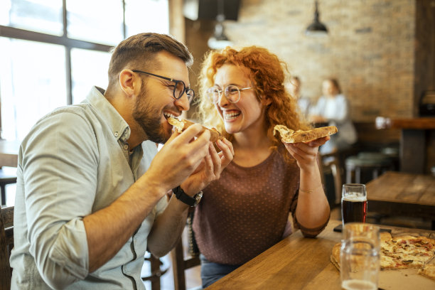 快乐的情侣吃披萨玩得很开心图片下载