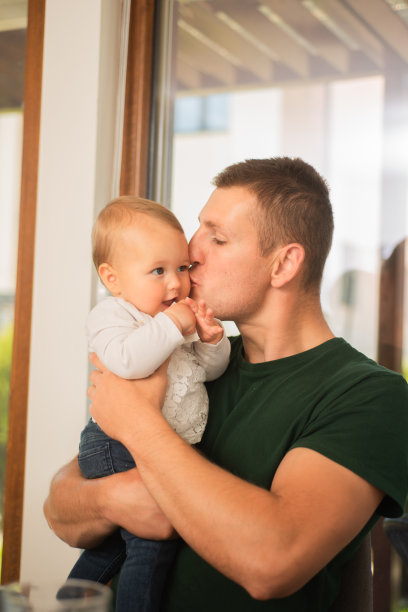 父亲抱着他的孩子，亲吻他的孩子图片下载