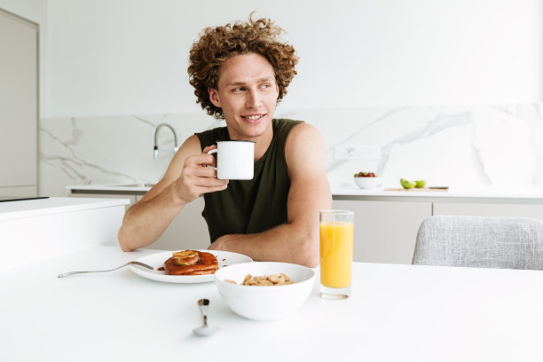 帅哥坐在厨房里喝咖啡图片下载