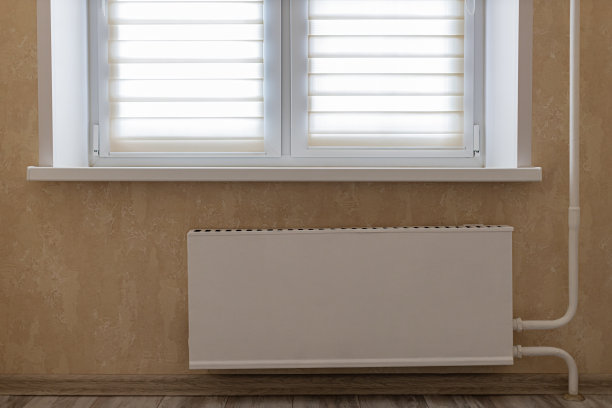 中央暖气暖气片位于窗下的墙壁上图片下载