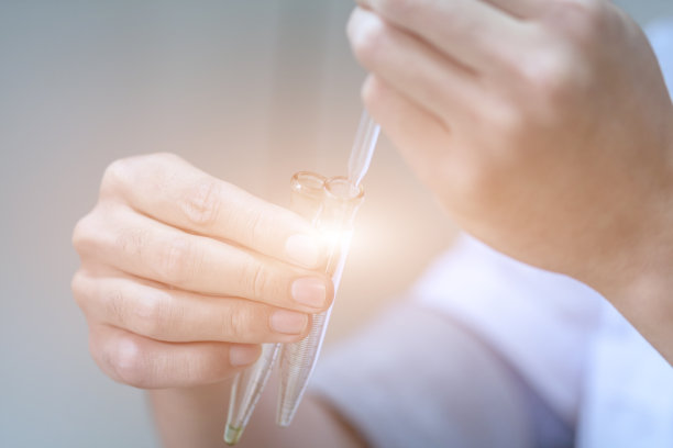 实验室技术员在实验室用显微镜做研究。科学家在科学实验期间拿着仪器，拿着工具，科学概念库存照片图片下载