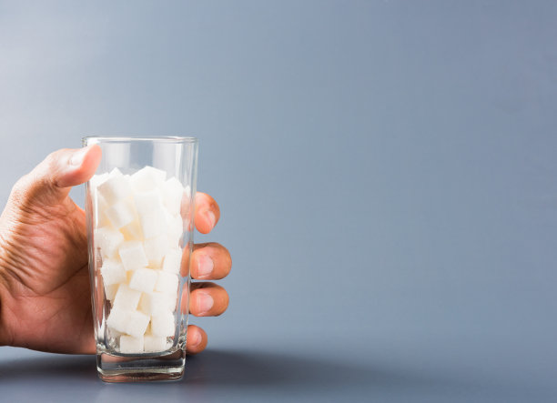 手握盛满白方糖的杯子图片下载