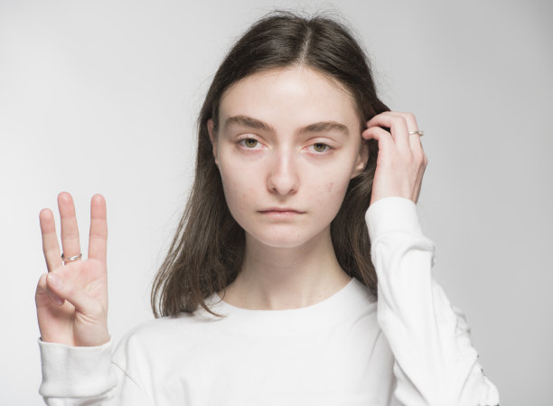 一个年轻的乌克兰女孩的特写照片，她的手在白色背景上显示数字图片下载