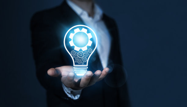 创新的技术和理念理念。的想象力。商人手持发光的灯泡和机械装置。创造性，灵感和想象力。图片下载