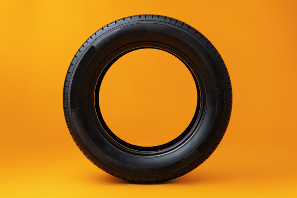 黄色背景上孤立的汽车轮胎，特写图片下载