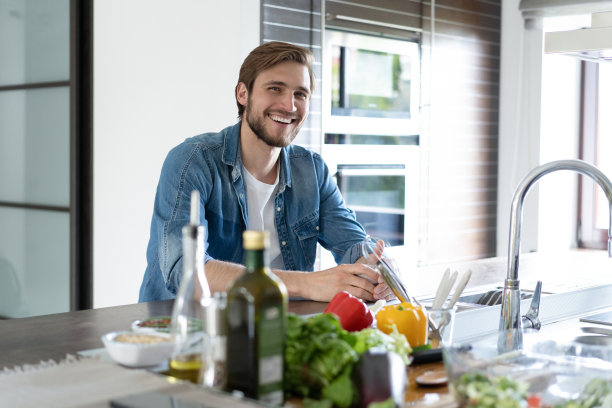 一名男子坐在厨房里，手里拿着一杯咖啡，目光移开，陷入沉思图片下载