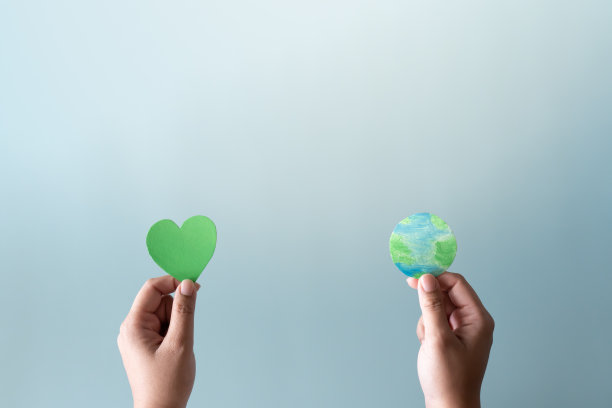 手捧大地，手捧绿色心形。以生态的心保护世界免受全球变暖的概念。图片下载