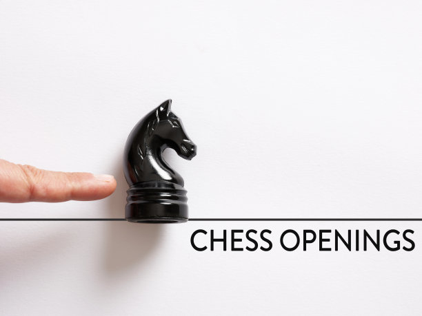 手指按下骑士棋子与消息象棋开口。国际象棋游戏开图片下载