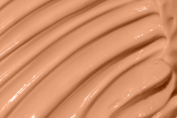 粉底，奶油纹理的底色。米色裸色粉底液质地，遮瑕膏涂抹涂抹滴。特写镜头宏。彩妆保湿霜图片下载