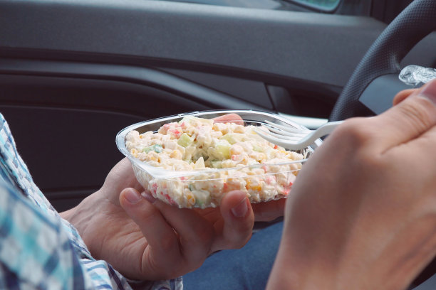 老兄，坐在车里，用一次性塑料盘子里的蛋黄酱吃沙拉图片下载