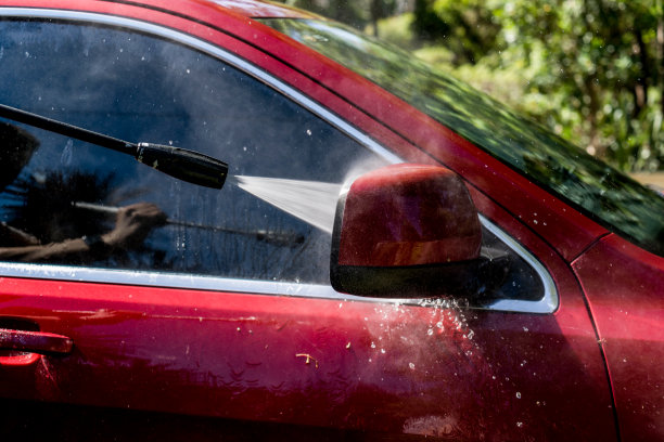 用高压清洗机清洗红色Suv四驱车的选择性聚焦镜头。洗车图片下载