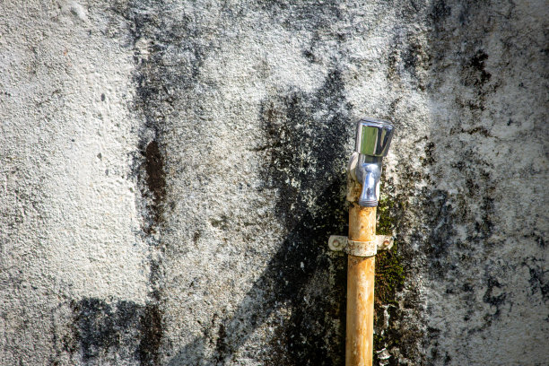 镀铬水龙头安装在建筑外部的墙壁上。图片下载