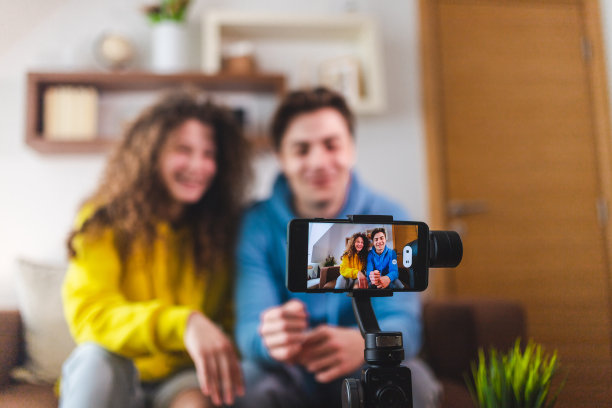 常平架上的智能手机在家里录制一对夫妇的视频图片下载
