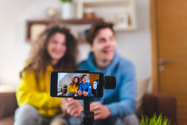 常平架上的智能手机在家里录制一对夫妇的视频图片下载