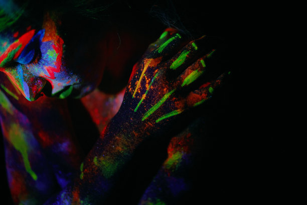 年轻女孩的肖像在紫外线灯光下霓虹灯妆在她的脸上图片下载