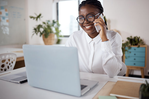 一个年轻的女商人在现代办公室里使用笔记本电脑和智能手机的照片图片下载