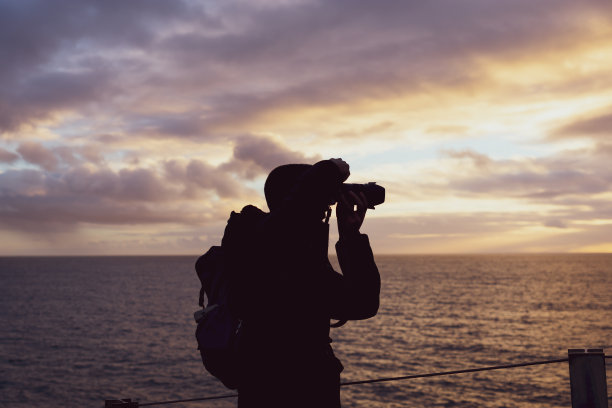 日落时分，游客在地狱博卡的悬崖上拍照图片下载