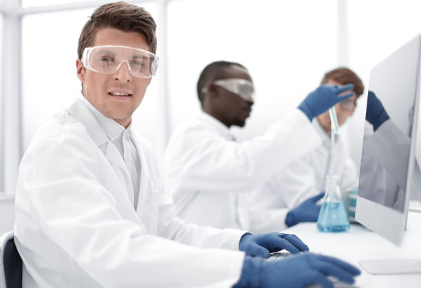 现代科学家坐在电脑显示器前图片下载