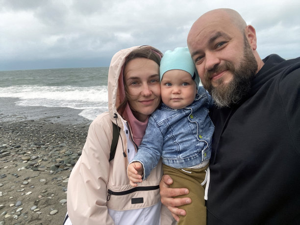 在海滩上，一个男人和他的家人拍了一张自画像图片下载