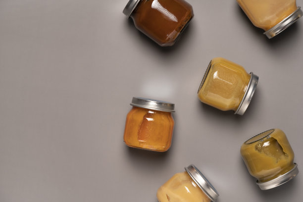 婴儿泥在灰色背景玻璃罐中。第一个婴儿食品概念。本空间图片下载