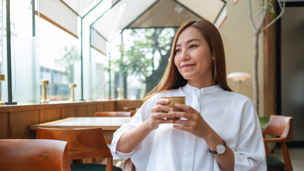 一个美丽的年轻亚洲妇女的肖像形象，在咖啡馆里喝咖啡图片下载