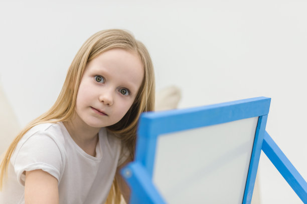 小女孩在家里的白板上画画。图片下载