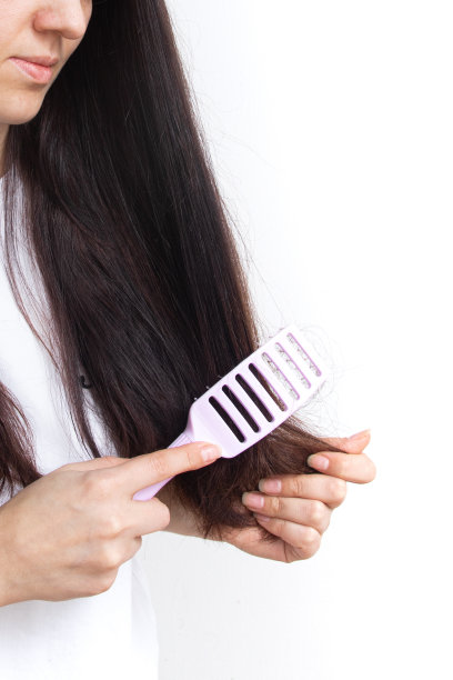 一个长头发的女孩在梳头。分叉和纠结的头发概念图片下载